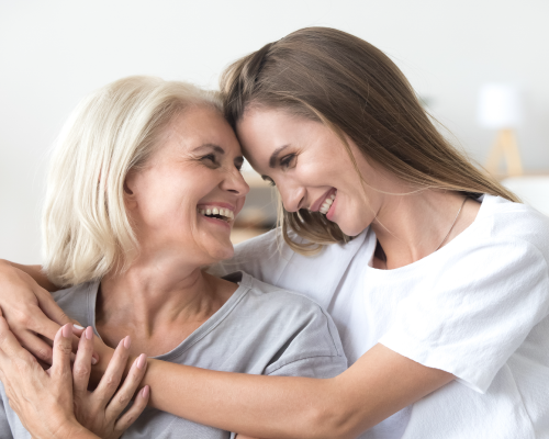 Adult Daughter and Older Mother Looking at One Another, Laughing and Embracing