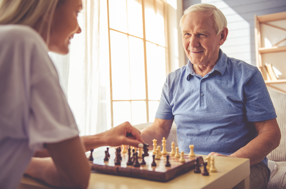 Young Woman and Older Man Playing Chess and Smiling