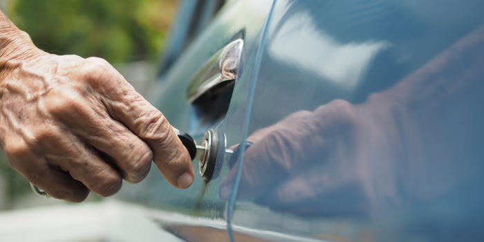 Hand of Older Man Using Key to Unlock Car Door