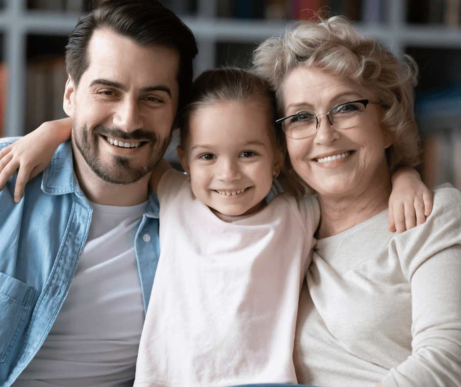 Three Smiling People Posed Closely - Older Mother, Adult Son, and Young Girl