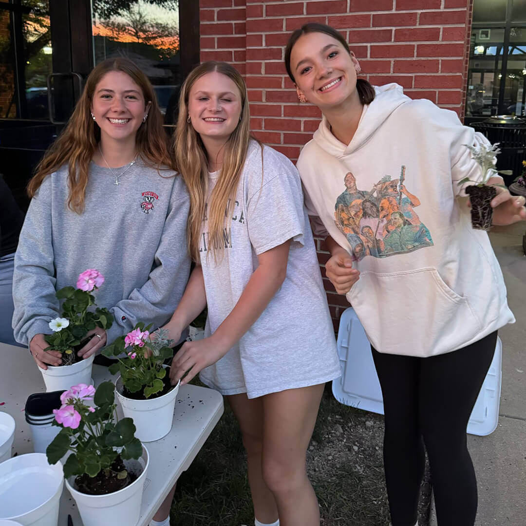 Three Bacoa Youth members with flowers